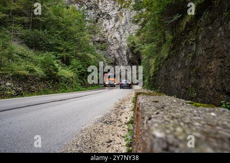 Fahrzeuge passieren eine enge Bergstraße in Vares, Bosnien 19.09.24, Vares : Symbolfoto, Illustrationsbild, Symbolbild, Illustrationsfoto, Alltagsszene Fahrzeuge passieren eine enge Bergstraße in Vares, Bosnien Ein LKW und ein auto fahren durch eine enge, kurvige Bergstraße in Vares, Bosnien, die durch massive Felswände und üppige Vegetation führt. Die Straße führt direkt in einen Felsentunnel, was die herausfordernde Infrastruktur und die natürliche Schönheit der Region hervorhebt. . Vares Hessen Bosnien-Herzegovine *** les véhicules traversent une étroite route de montagne à Vares, Bosnie 19 09 24, va Banque D'Images