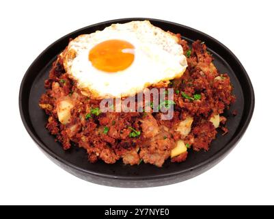 Farine traditionnelle de hasch de bœuf corned avec un œuf frit isolé sur un fond blanc Banque D'Images