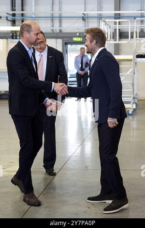 Le prince de Galles serre la main de David Beckham à son arrivée à la RAF Northolt pour voir les deux nouveaux hélicoptères London Air Ambulance Charity. L'association caritative a reçu deux nouveaux hélicoptères H135 dans le cadre de l'appel de fonds « Up Against Time » lancé en 2021 et levé un total de 16 millions de livres sterling. Date de la photo : mardi 1er octobre 2024. Banque D'Images