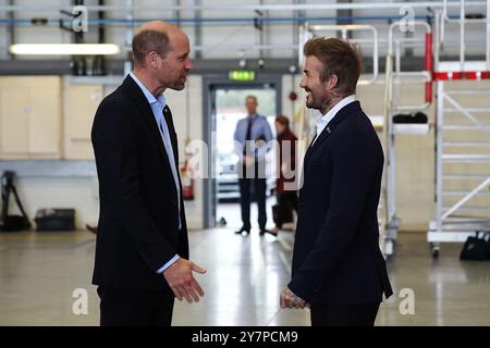 Le prince de Galles parle avec David Beckham à son arrivée à la RAF Northolt pour voir les deux nouveaux hélicoptères London Air Ambulance Charity. L'association caritative a reçu deux nouveaux hélicoptères H135 dans le cadre de l'appel de fonds « Up Against Time » lancé en 2021 et levé un total de 16 millions de livres sterling. Date de la photo : mardi 1er octobre 2024. Banque D'Images