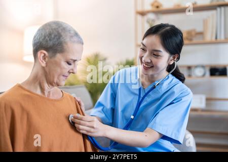 Infirmière effectuant un bilan de santé lors de la visite à domicile pour une femme âgée dans un cadre confortable de salon Banque D'Images