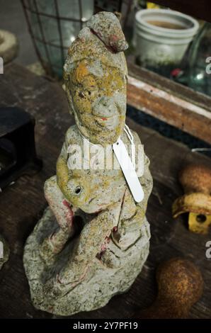 Un vieux gnome de jardin altéré à vendre à un étal antique. Banque D'Images