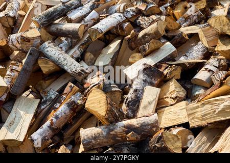 Pile de bois de chauffage de bouleau avec bloc de coupe à la main. Bois de chauffage haché pour l'hiver. Beaucoup de bois de chauffage - récolte de bois pour chauffer la maison. Pho. Horizontale Banque D'Images