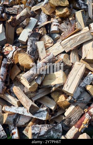 Pile de bois de chauffage de bouleau avec bloc de coupe à la main. Bois de chauffage haché pour l'hiver. Beaucoup de bois de chauffage - récolte de bois pour chauffer la maison. Photo verticale Banque D'Images