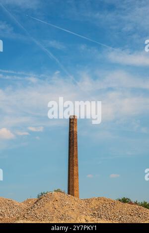 Vieille cheminée de fumée d'usine faite de briques contre le ciel bleu Banque D'Images