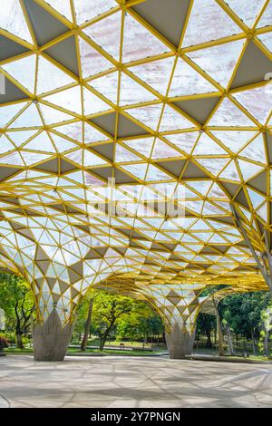 Structure architecturale moderne avec toit géométrique jaune et grand espace ouvert entouré de verdure et d'arbres dans le jardin botanique de Perdana, Kuala Banque D'Images