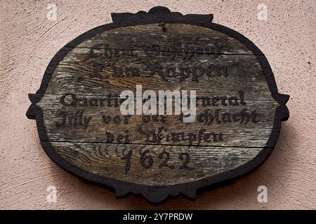 Plaque en bois sur l'ancien Gasthaus zum Rappen sur la Marktplatz à Bad Wimpfen, Bade-Württemberg, Allemagne. Il marque le séjour ici en mai 1622 de Johann Tserclaes, comte von Tilly, la nuit avant que ses troupes et les forces hispano-impériales ne défassent une armée protestante à la bataille de Wimpfen, parmi les engagements les plus sanglants de la guerre de trente ans. Banque D'Images