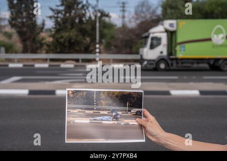 26 septembre 2024, Israël, tel Aviv : une photo montre une femme tenant une photo montrant un ambulancier israélien couvrant le corps d'un homme armé palestinien mort, suite aux attaques des militants islamistes du Hamas, le 7 octobre 2023. Le 7 octobre 2023, le Hamas a lancé une attaque surprise contre Israël avec des tirs de roquettes et des infiltrations terrestres depuis Gaza, entraînant de lourdes pertes et la capture de nombreux otages. En réponse, Israël a déclaré la guerre à l'enclave palestinienne, qui a dégénéré en une guerre à grande échelle conduisant à une vague de troubles à travers le moyen-Orient. Photo : Ilia Yefimovich/dpa Banque D'Images