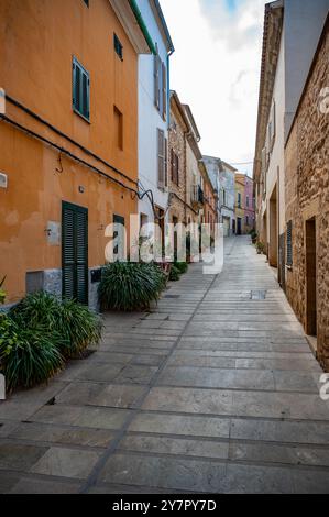 Une rue étroite pittoresque avec des bâtiments colorés et des plantes en pot dans une ville méditerranéenne. Banque D'Images