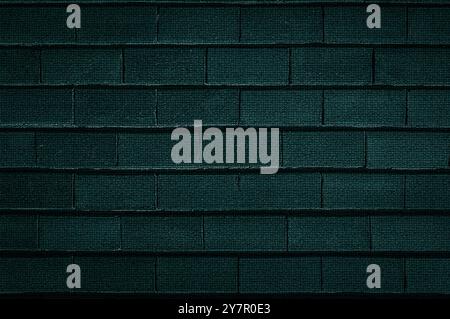 La texture de fond d'un vieux mur de briques rugueuses est vert foncé en gros plan Banque D'Images