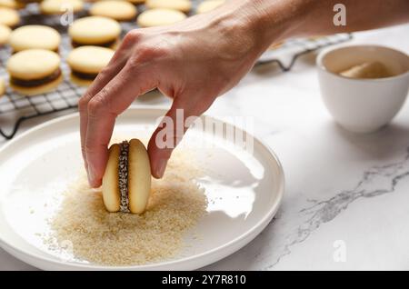 Mettre la noix de coco dans un alfajor de fécule de maïs. Banque D'Images