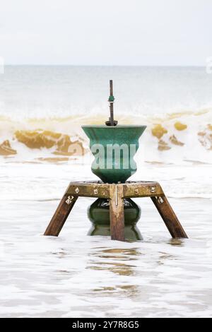 Installation artistique en mer par Marcus Vergette. Time and Tide Bell. dans le surf sur la plage. Happisburgh, Norfolk, Angleterre. Banque D'Images