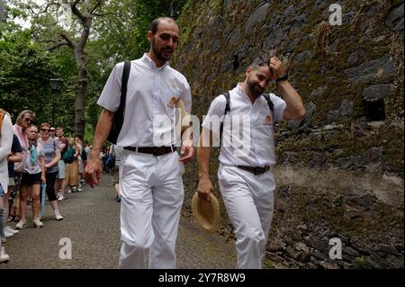 Deux carreiros partagent un moment de lumière, chapeaux à la main, alors qu’ils marchent vers leur prochaine promenade en traîneau à monte Banque D'Images