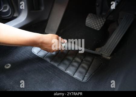 Homme nettoyant tapis de sol de voiture avec aspirateur, gros plan Banque D'Images