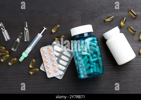 Pharmacien. Différentes pilules, bouteilles en plastique, seringue et ampoules sur table en bois gris, pose à plat Banque D'Images