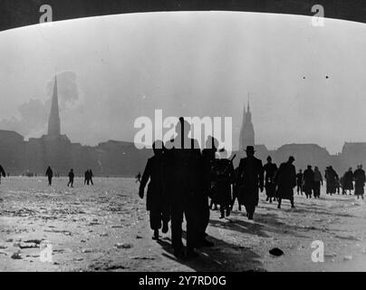 LES VOIES NAVIGABLES ALLEMANDES REGORGENT DE GLACE. Le 4 février 1954, la plupart des voies navigables allemandes sont pleines de glace, ce qui immobilise le trafic des barges, alors que la vague de froid la plus sévère de l'Allemagne depuis 1947 est entrée dans sa deuxième semaine. Les températures dans la région de Francfort étaient aussi basses que 6 degrés en dessous de zéro. La photo de l'INP montre des hamburgers profiter de la rivière Alster épaisse gelée et couper court à leurs promenades en traversant la rivière à pied. Photos d'actualités internationales. Banque D'Images