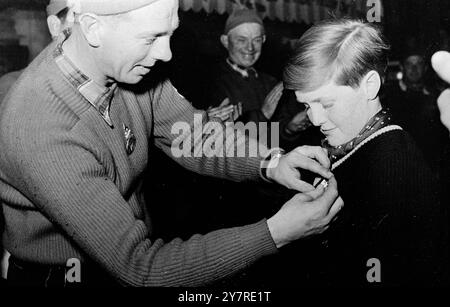 WINSTON CHURCHILL PETIT-FILS OBTIENT UN DIPLÔME DE SKI. Winston Churchill, 12 ans, petit-fils du premier ministre britannique Sir Winston Churchill, a reçu le diplôme de ski-test des mains de son moniteur de ski Kitzbuehel. Le garçon bavé a été décrit par son instructeur comme un jeune homme très courageux qui devient encore plus dur quand les choses deviennent difficiles. Un moniteur de ski de Kitzbuehel épingle le diplôme 'ski test' sur la poitrine de Winston Churchill, 12 ans. Banque D'Images
