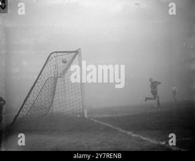 Le brouillard arrête de jouer à l'Arsenal Stadium. Le 2,1.54, après qu'Arsenal ait pris une avance de trois buts contre Aston Villa à l'Arsenal Stadium, le brouillard s'est abaissé et a arrêté le jeu. Arsenal rencontre Villa à la F.A. Cup samedi prochain. I.N.P. photo montre : Jones, le gardien de but de Villa, fait un effort vain pour sauver un trajet de trente mètres de Holton, le centre de l'Arsenal en avant. Photo de J. Waldorf. EM/73579. Photos d'actualités internationales. Banque D'Images