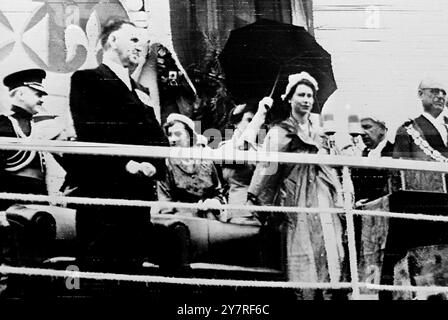 La reine parle sous la pluie (photo par radio) 23.12.53 73430. La pluie s'est déversée hier à Auckland, en Nouvelle-Zélande, alors que la reine se tenait sur un dais ouvert devant la mairie, attendant de prononcer un discours en réponse à la loyale adresse de bienvenue. L'adjoint au maire, M. Keith Buttle, a enlevé son imperméable en plastique gris et l'a remis au premier ministre, M. Sydney Holland, qui l'a placé autour des épaules de la reine. P.P.C. photo montre sa majesté la reine faisant un discours sous la pluie à son arrivée à Auckland. Le premier ministre de la Nouvelle-Zélande, Mr. Sydney Holland, est vu à gauche. 73436 (S& Banque D'Images