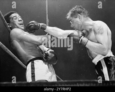 OLSON REMPORTE LE TITRE MONDIAL DES POIDS MOYENS AU 22.10.53. L'américain Carl 'Bobo' Olson a devancé le britannique Randolph Turpin pour remporter le championnat du monde incontesté de boxe poids moyens au Madison Square Garden, New York, hier soir. Auparavant, chaque homme avait été reconnu dans son propre pays comme champion du monde. Turpin reçoit un droit de BOBO OLSON lors du combat pour le titre au Madison Square Garden, aux États-Unis Banque D'Images