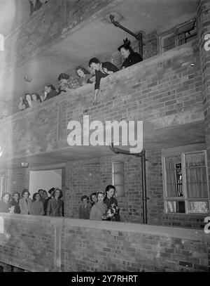 PRINCESS MARGARET OUVRE DE NOUVEAUX APPARTEMENTS. 22.10.53. S.A.R. la Princesse Margaret a ouvert cet après-midi trois nouveaux blocs d'appartements sur le domaine Tachbrook, Westminster, Londres. Elle a été accueillie par le maire et maire de Westminster et Sir John Wrigley, vice-président du Westminster Housing Trust. La photo montre des locataires de l'étage au-dessus de Peer vers le bas à la Princess alors qu'elle marche le long d'un balcon pour inspecter certains des nouveaux appartements. Photo de Jack Davies / INP Banque D'Images