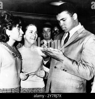 CLAY AUTOGRAPHSBoston, Massachusetts, Etats-Unis : le champion du monde poids lourds Cassius Clay est photographié hier en train de signer des autographes pour Evelyn Caposselas (à gauche) et Karen Maguire, toutes deux secrétaires au bureau du greffier ici. Clay était présent pour le procès pour agression et coups et blessures de 11 musulmans noirs - une secte extrémiste à laquelle il appartient. Aujourd’hui, il va subir un examen physique pour déterminer sa santé après l’opération de hernie qui a causé le report de son combat avec Liston l’année dernière. 13 janvier 1965 Banque D'Images