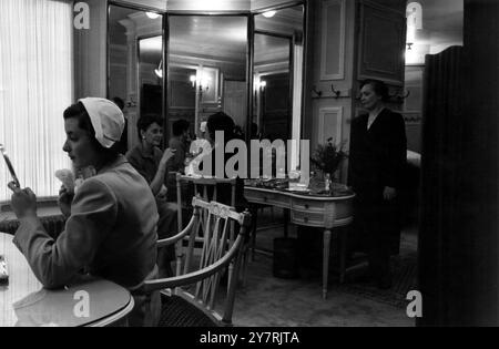 LE RITZ HOTELLondon Angleterre : tous les jours, 200 000 personnes passent devant le Ritz Hotel à Piccadilly. Moins de la moitié pour cent passent par ses portes élégantes. Quelle vie de grandeur flunkeyed y est tenue ? Cette série d'images montre une journée dans cet hôtel de luxe avec son personnel attentionné et ses salles de réception grandioses. Spectacles de photos : la salle de poudre pour dames du Ritz est naturellement pleine de miroirs. En arrière-plan, on peut voir Miss Irene Worth the actrice et l'honorable Mrs Sherek, sœur du comte de Falmouth. Le salon de coiffure pour dames était à l'étage. 7 octobre 1950 Banque D'Images