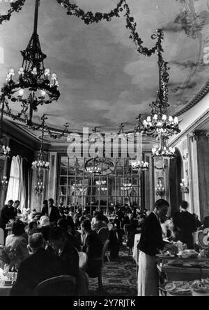 LE RITZ HOTELLondon Angleterre : tous les jours, 200 000 personnes passent devant le Ritz Hotel à Piccadilly. Moins de la moitié pour cent passent par ses portes élégantes. Quelle vie de grandeur flunkeyed y est tenue ? Cette série d'images montre une journée dans cet hôtel de luxe avec son personnel attentionné et ses salles de réception grandioses. Spectacles de photos : le restaurant très fréquenté où les serveurs assistent aux visiteurs aux tables pour le déjeuner. 7 octobre 1950 Banque D'Images