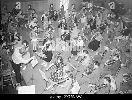 ORCHESTRE DES JEUNES ' TUNES UP ' POUR LE PREMIER CONCERT DE LONDRES soixante garçons et 45 filles , membres de l'Orchestre national des jeunes , se préparent à la Hitchin ( Hertfordshire ) Girls Grammar School pour leur premier concert à Londres - au Central Hall , Westminster le 29 avril . Le concert sera le point culminant d'une semaine de cours musical que les garçons et les filles ont pendant leurs vacances scolaires. L'Orchestre National des jeunes , dans lequel tous les joueurs sont âgés de 14 à 18 ans , a été fondé il y a deux ans pour poursuivre l'éducation musicale de jeunes instrumentistes prometteurs . Le concert , Banque D'Images