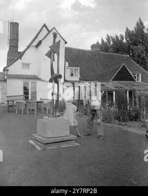 HENRY MOORE, SCULPTEUR - Henry Moore dans le jardin de sa maison de campagne Hogland, Perry Garden, beaucoup Hadaam, Herts. En arrière-plan se trouve le chalet du XVe siècle où il vit. Avec le sculpteur se trouve Mary, sa fille de 6 ans. 15 août 1952 Banque D'Images