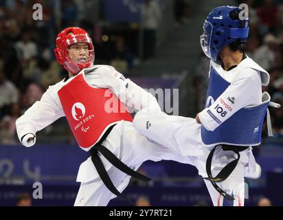 Thanwa KAENKHAM de Thaïlande (bleu) vs Bopha KONG de France (rouge) au concours para Taekwondo - hommes K44 -58kg de repêchage au Grand Palais, Paris, aux Jeux paralympiques de 2024. Banque D'Images