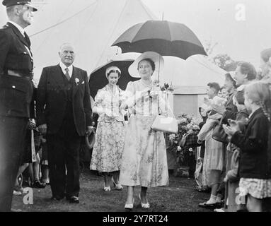 SOURIRES ROYAUX SOUS LA PLUIE AU SPECTACLE FLORAL DE SANDRINGHAM 31.7,53. La reine Elizabeth la reine mère et S.A.R. la princesse Margaret ont assisté au Sandringham Flower Show mercredi. La photo montre, sans être découragées par la pluie, la Reine mère et la Princesse marchent souriantes autour du spectacle accompagné de Mr. C. H. Cook, le président. 31 juillet 1953 Banque D'Images