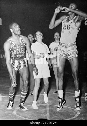 LE PRINCE HÉRITIER CONSTANTINE COMMENCE LE MATCH 30.7.53 le prince héritier du trône grec, âgé de 13 ans, le prince héritier Constantine, thre dans le ballon pour le début du match d'ouverture entre les équipes de basket-ball américaines les Harlem Globe Trotters et les Celtics de New York, quand ils ont joué à Athènes ce wekd lors de leur tournée mondiale. La photo montre éclipsé par les six pieds des équipes de basket-ball de crack, le prince héritier de 13 ans lance avec enthousiasme le ballon pour commencer le match à Athènes. 30 juillet 1953 Banque D'Images