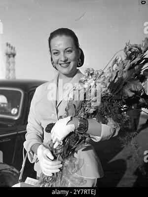 LA STAR ITALIENNE ARRIVE À LONDRES POUR "STAR OF INDIA" 21.7.53La star de cinéma italienne Yvonne Sanson est arrivée à Londres hier soir pour faire son premier film en Grande-Bretagne "Star of India". Yvonne, aux cheveux cuivrés et aux yeux verts, qui a réalisé 30 films sur le continent, est née à Salonique en 1926 d’un père franco-russe et d’une mère turco-polonaise mais s’est installée en Italie. Quelque part dans son ascendance, elle a des parents anglais qui vivent dans le Devon et elle espère visiter ces derniers pendant qu'elle est dans ce pays. Expositions photographiques avec un bouquet de fleurs et un sourire éblouissant, Yvonne Sanson fait son premier tour de Londres Banque D'Images