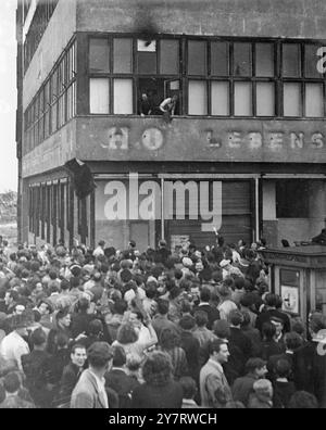 LOI MARTIALE À BERLIN-EST 17.6.53 la loi martiale a été déclarée hier à Berlin-est à la suite d'émeutes généralisées contre l'administration soviétique. La photo montre la police est-allemande jeter ses uniformes par la fenêtre d'un grand magasin appartenant à l'État dans la zone de Berlin-est cet après-midi. Les Russes ont déclaré la loi martiale cet après-midi après que 100 000 Allemands se soient émeutés, déchirant le drapeau rouge et criant "nous voulons être libres". Les policiers ont été assiégés dans le magasin et ont jeté leurs uniformes en signe de reddition. 17 juin 1953 Banque D'Images