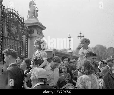 LES ENFANTS OBTIENNENT LA MEILLEURE VUE DE LA GARDE DU PALAIS.. DE LEURS ÉPAULES DE PÈRES ...... 24.5,53. Des milliers de londoniens heureux couronnement et d'autres aujourd'hui affluent vers Buckingham Palace et pointent le long de la route que prendra la procession. Le soleil était flamboyant, les décorations étaient gays et colorées et les gens entraient dans l'esprit de la chose et commençaient vraiment à s'amuser... PHOTOS MONTRENT : deux petits enfants perchés haut sur les épaules de leur père alors qu'ils rejoignent la foule à l'extérieur du palais de Buckingham.24 mai 1953 Banque D'Images