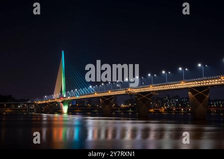 Pont Seongsu illuminé la nuit à Séoul, Corée du Sud. Les lumières colorées se reflètent sur la surface de l'eau, créant une atmosphère tranquille. Banque D'Images