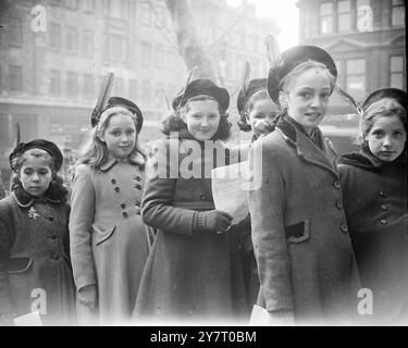 JOUR DE LA PLUME ROUGE POUR Une ÉCOLE LONDONIENNE 20-2-52 aujourd'hui était le jour de la plume rouge pour les enfants de l'école Sir John Cass, le jour où ils célèbrent le 291e anniversaire de la naissance de leur fondateur, dont la plume s'est tachée de sang alors qu'il mourait en réprimant son testament. I.N.P. PHOTOS MONTRE :- enfants de l'école Sir John Cass, portant des plumes rouges en mémoire de leur fondateur, arrivant pour le service annuel à l'église Botolph, Aldgate, Londres, aujourd'hui. Photo de J. Davies. PHOTOS D'ACTUALITÉS INTERNATIONALES. D/59943 Banque D'Images
