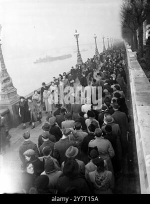 Maintenant, c'est une double file d'attente d'hommage - et il s'étend sur des kilomètres. La file d'attente à déposer devant la catafalque du roi George VI dans le Great Hall de Westminster de Londres s'étend maintenant sur des kilomètres. Il va de la Grande salle elle-même le long de la rivière jusqu'au pont Lambeth, sur le pont et de retour le long de l'autre côté jusqu'au pont Westminster, puis il fait marche arrière et passe à nouveau sur le pont Lambeth. Il s'agit maintenant d'une double file d'attente et chaque file d'attente est d'environ six ou huit personnes de profondeur. Voici une scène montrant la double file d’attente du côté Lambeth de la rivière en regardant vers l’hôpital St Thomas 13 février 1952 Banque D'Images