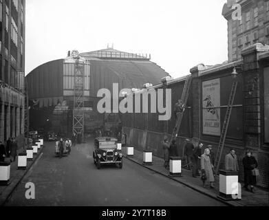 LA FIXATION DES DRAPS VIOLETS À LA GARE DE PADDINGTON 18-2-52 I.N.P. PHOTO MONTRE:- Une vue générale montrant l'entrée de la gare de Paddington de Londres étant drapée de violet royal prêt pour l'arrivée du cort funéraire ege vendredi pour le dernier voyage du roi George VL à Windsor, où sa «défunte Majesté sera enterrée. En haut de la photo, un peintre dédédécore les armoiries. Ficture par E. Martlew d/59659 A 442/COM/ PHOTOS D'ACTUALITÉS INTERNATIONALES. Banque D'Images