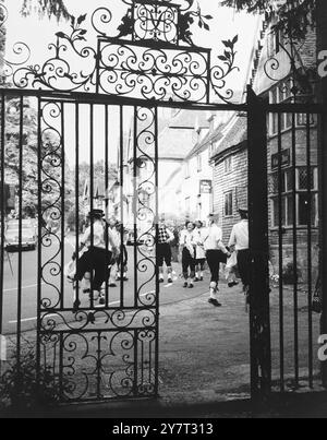 Les danseurs Morris dans le village de Chiddingstone, Kent, Angleterre, Royaume-Uni, dansent devant le Castle Inn, vu à travers la porte ornée menant au château de Chiddingstone. - - 10 juillet 1960 Banque D'Images