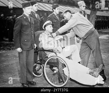 HÉROS NAVAL HONORÉ PAR LE COMMANDANT DE LA CINQUIÈME ARMÉE POUR SA BRAVOURE EN L'EMMENANT À LA TÊTE DE PONT expositions de photos : assis dans un fauteuil roulant, le lieutenant George E Patterson, qui a été blessé lorsqu'il commandait le bateau qui a emmené le général Mark Clark, commandant de la cinquième armée, à la tête de pont d'Anzio, reçoit l'US Navy Silver Star pour sa bravoure. Le général Clark, qui n'a pas été blessé, fait la présentation. Deux hommes sur le bateau ont été tués et trois blessés. 21 mars 1944 Banque D'Images