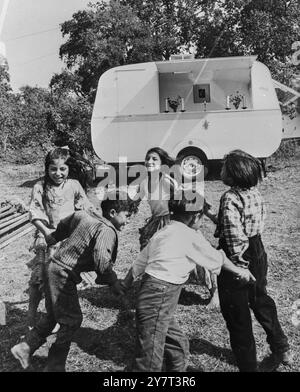 LES ROMS ATTENDENT LE PAPE : POMEZIA, ITALIE : des enfants roms jouent dans le camp à l'extérieur de Rome, que le Pape doit visiter dimanche prochain, à l'occasion de son 68e anniversaire. Des centaines de familles roms sont arrivées pour un pèlerinage spécial, le premier dans l’histoire de l’Église, pour honorer le pape. L'autel portatif en arrière-plan a été donné au pape lors d'une visite précédente dans le quartier, et il l'a donné aux Roms pour des messes en plein air. 23 septembre 1965 Banque D'Images