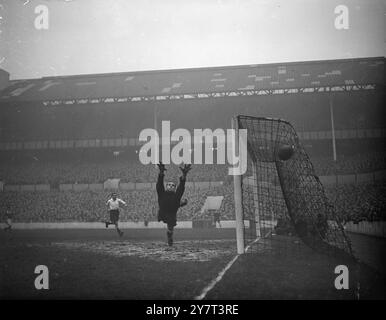 LES MAINS AGRIPPANTES comme une ombre horrible jetée sur un blind sont celles du gardien de but de Tottenham Hotspur, Ted Ditchburn, alors qu'il plonge en avant pour faire une sauvegarde dans le match de première division contre Middlesbrough au White Hart Lane Ground, Londres aujourd'hui. Le match était de 3-3 . 2 décembre 1950 Banque D'Images