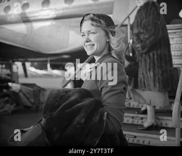 BEAUTÉ AVEC Un ARC Camilla Wicks , violoniste californienne de 21 ans, décrite comme la plus belle musicienne du monde, est arrivée aujourd'hui à l'aéroport Northolt, Middlesex, pour faire ses débuts britanniques au Royal Albert Hall, Londres, le 3 décembre. Camilla a refusé les offres tentantes d'Hollywood de consacrer sa vie au violon. Ses débuts à Londres, avec le London Symphony Orchestra, et une tournée européenne. IMAGES MONTRENT:- belle Camilla Wicks à l'arrivée à l'aéroport Northolt aujourd'hui de Stockholm. 1950 Banque D'Images