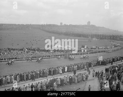 SCÈNE LINCOLN LE GRAND JOUR avec la cathédrale historique de Lincoln en arrière-plan , et des milliers de parieurs d'espoir bordant les rails , les coureurs dans le Castle plate - la première course de la journée - compléter la distance de six furlongs . L'occasion a été la réunion du centenaire du Lincolnshire handicap qui a suivi plus tard. Vainqueur de la plaque du château avec Evesham , monté par E.C. Elliott , deuxième MARCHE d'OR , avec ARUN , troisième . 20 mars 1949 Banque D'Images