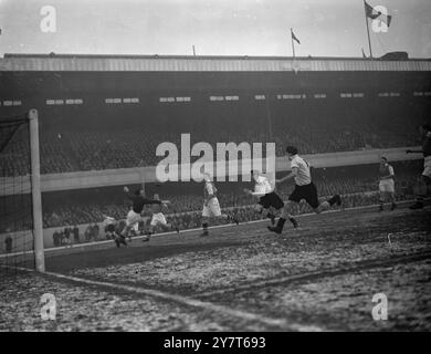 PLONGER PAR SWINDIN George SWINDIN , gardien de but de l'Arsenal , plonge en vain pour arrêter une passe de Jackie CHEW ( extrême gauche ) Burnley dehors à droite , à Bill Holden , ( extrême droite ) , Burnley centre avant , pendant le match de football de première division à Highbury , Londres , Holden a marqué le premier but de Burnley . 16 décembre 1950 Banque D'Images