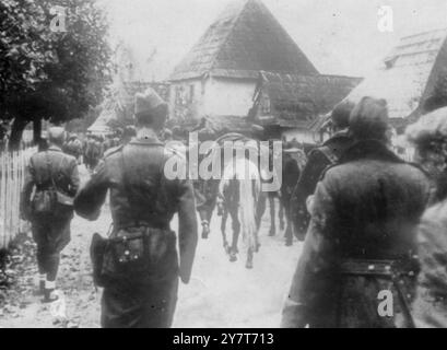 LA GUÉRILLA EN YOUGOSLAVIE 1944 L'une des nouvelles photographies de la Yougoslavie, où les armées de guérilla ont remporté de nombreux succès contre les forces allemandes d'occupation et leurs partisans quislateurs. Remarquable est le fait que les partisans ont contraint les Allemands à garder des forces considérables attachées en Yougoslavie. LA PHOTO MONTRE:- Une colonne d'approvisionnement partisane passant par un village bosniaque. Février 1944 Banque D'Images