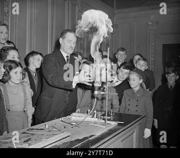 INTÉRÊT FLAMBOYANT L'amour de chaque enfant pour le feu d'artifice est reflété dans les regards d'un intérêt intense donné ici à ALAN ST HILL BROCK, A.R.T.B.A. comme il démontre avec des ingrédients flamboyants lors d'une conférence illustrée de feux d'artifice pour enfants à la Royal Society of Arts à John Adam Street, Adelphi , Londres , aujourd'hui ( vendredi ) . M. Brock est administrateur d'une firme de feux d'artifice. 29 décembre 1950 Banque D'Images