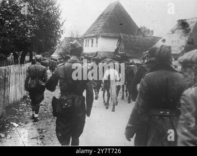 LA GUÉRILLA EN YOUGOSLAVIE 1944 L'une des nouvelles photographies de la Yougoslavie, où les armées de guérilla ont remporté de nombreux succès contre les forces allemandes d'occupation et leurs partisans quislateurs. Remarquable est le fait que les partisans ont contraint les Allemands à garder des forces considérables attachées en Yougoslavie. LA PHOTO MONTRE:- Une colonne d'approvisionnement partisane passant par un village bosniaque. Février 1944 Banque D'Images